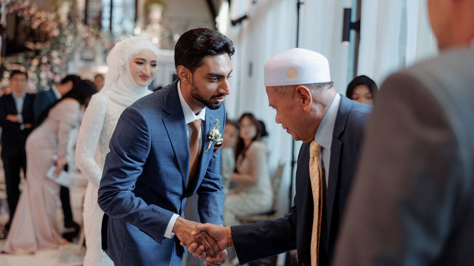 เจ้าบ่าวคารวะและจับมือวะลีย์ (ผู้ปกครองเจ้าสาว) ในพิธีนิกะห์ โดย ARAYA — Groom greeting the wali (bride guardian) at a nikah